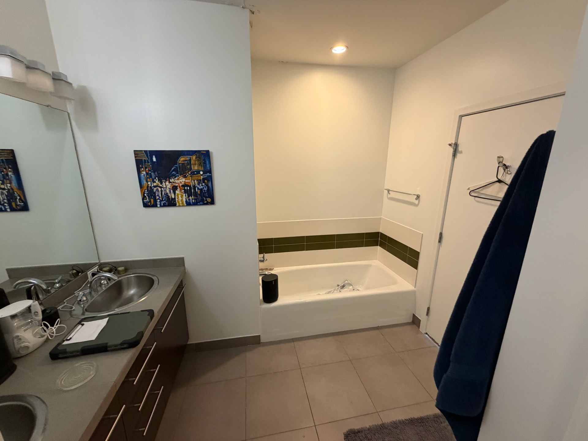 Original bathroom with dated tub and laminate vanity