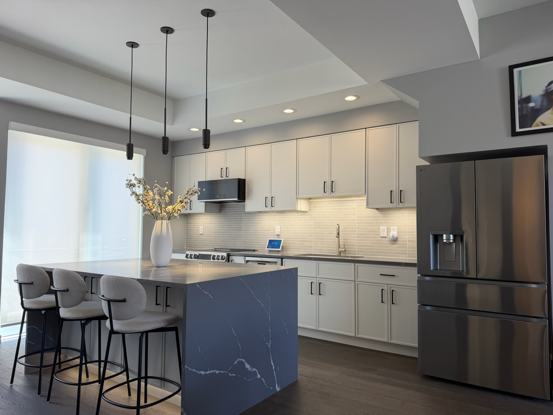 Wide view of the remodeled kitchen with waterfall quartz island