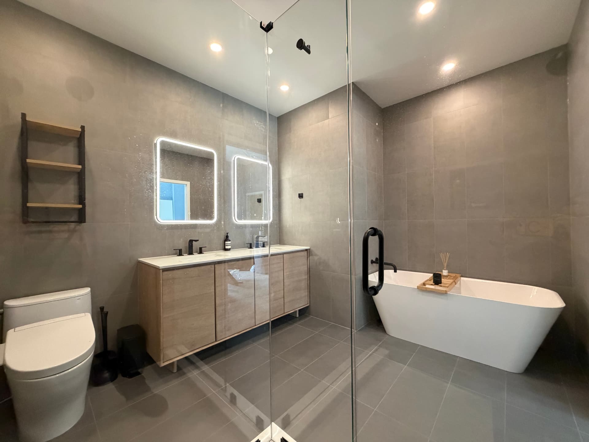 Freestanding soaking tub with matte black wall-mounted filler