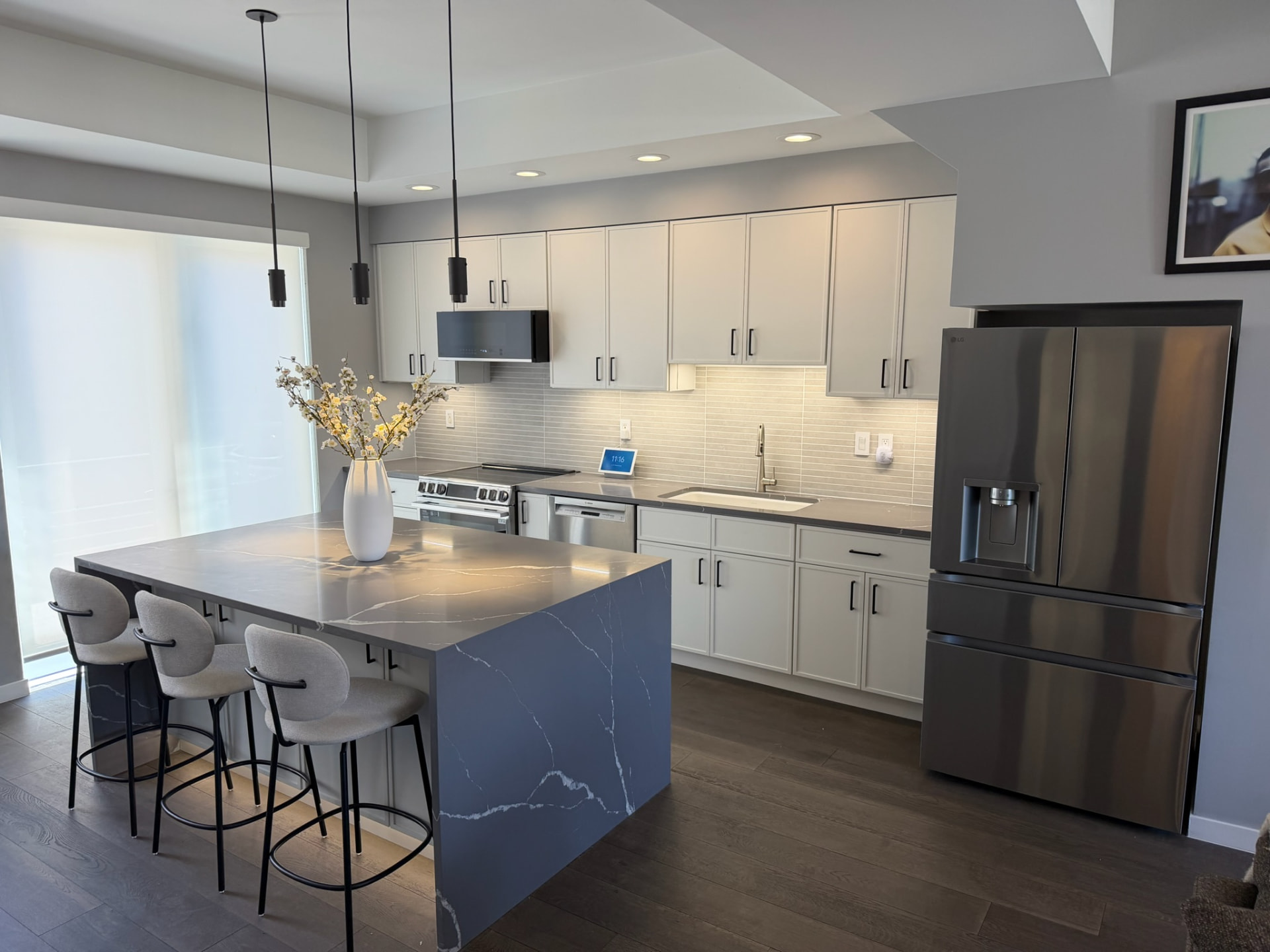 Modern kitchen with island, pendant lighting, and stainless appliances after Sinkovec Contracting remodel